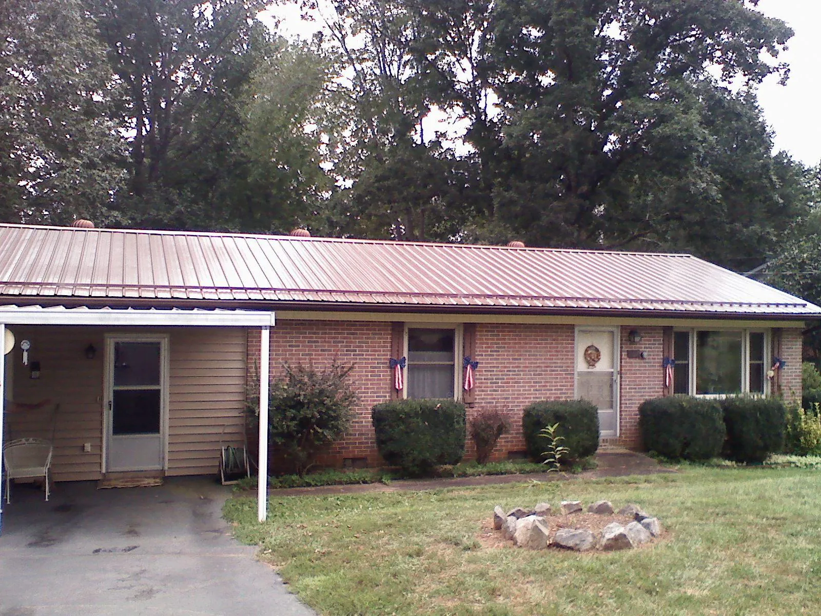 Bronze metal roof and carport on a brick ranch home — Roof Repair work by our crew in Benton