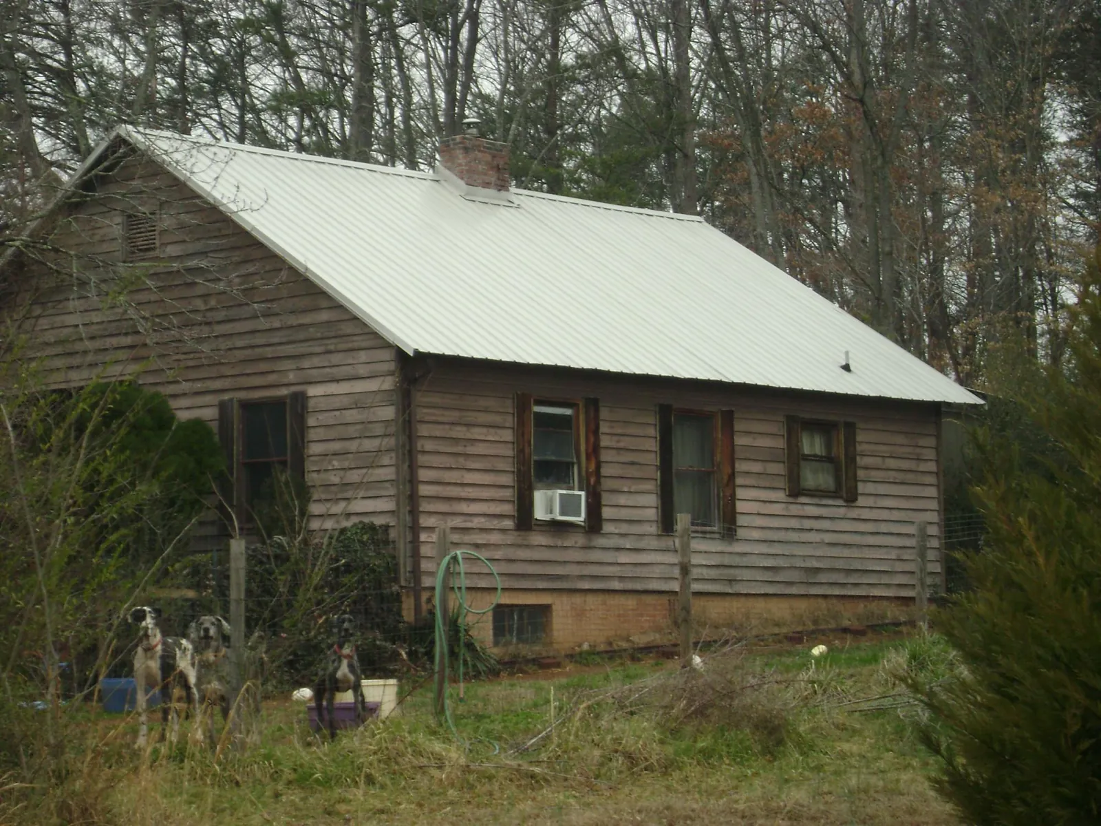 White metal roof on an old wood sided farmhouse, from a Metal Roof Installation job in Benton